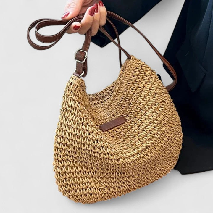 Khaki woven half-moon shoulder bag with brown leather strap and front tab