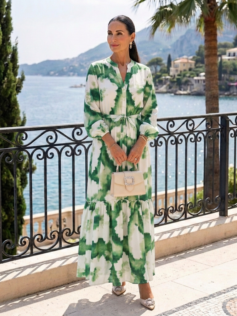 Long sleeve tie-waist tiered maxi dress in green and white floral print, standing