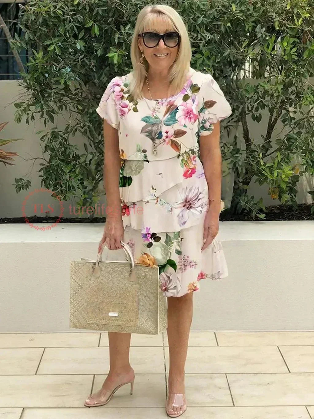 Tiered ruffled floral dress with short sleeves, light base with pink and purple blooms
