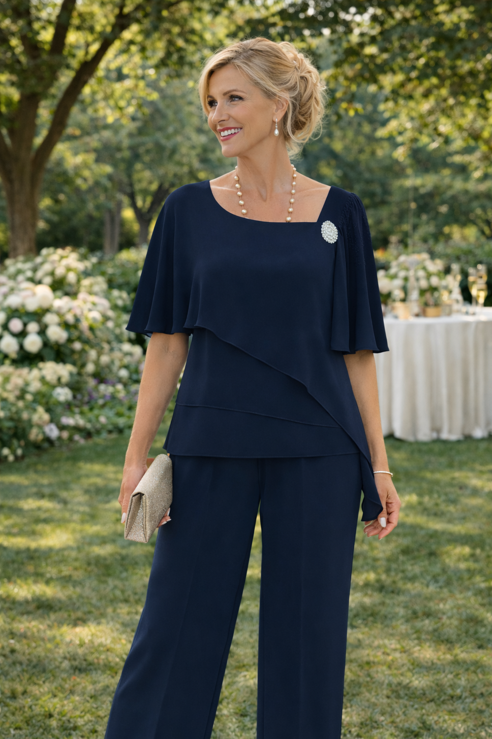 Dark navy draped top and matching pants set with cape sleeves and brooch