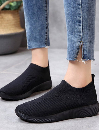 Black slip-on knit sneakers with cushioned sole and textured stretch upper