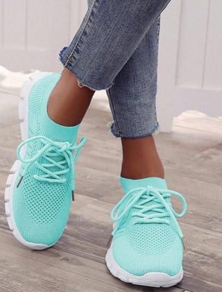 Light green performance running sneakers with lace-up mesh upper and white sole