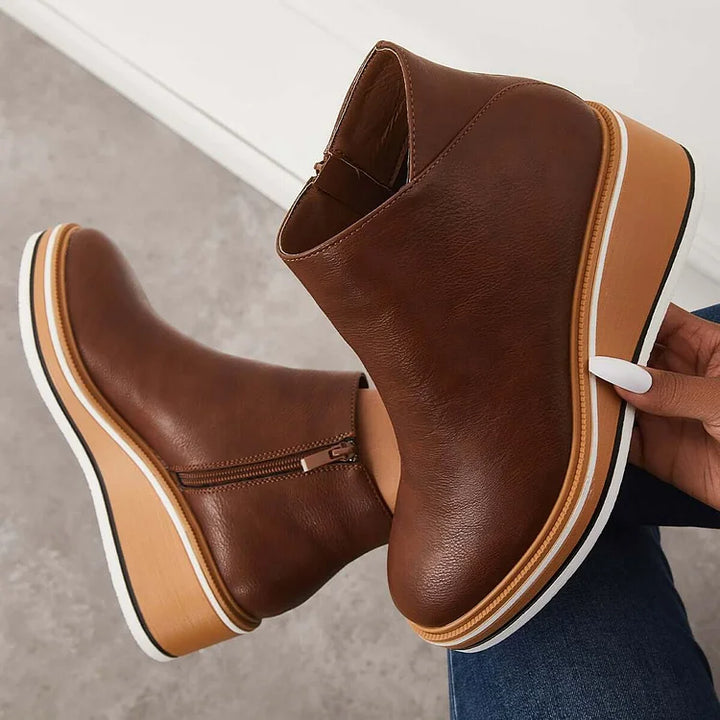 Dark brown ankle boots with side zipper and tan platform wedge with white sole edge