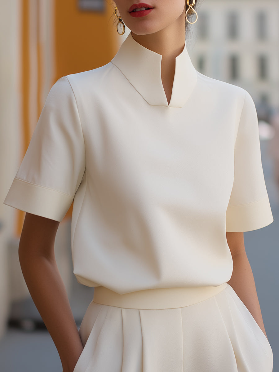 White structured blouse with stand collar and short sleeves, smooth minimalist front