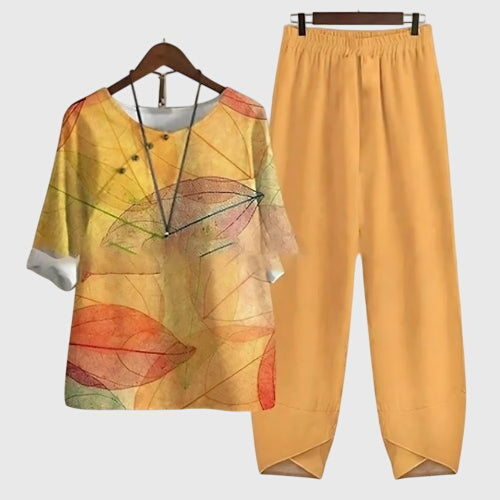 Two-piece set: mustard-orange short-sleeve top and matching pants, multicolor leaf artwork