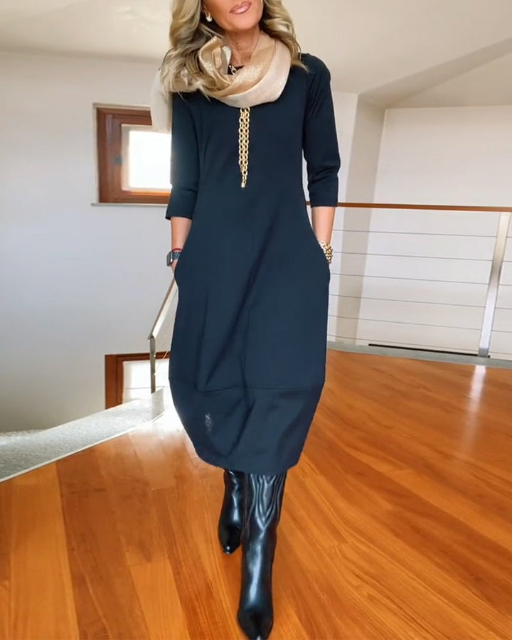 Dark solid midi dress with 3/4 sleeves and gold chain neckline detail
