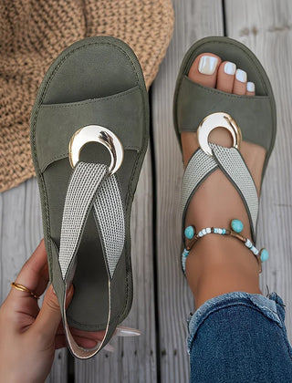 Green flat sandals with oval metal buckle, textured strap and beaded details