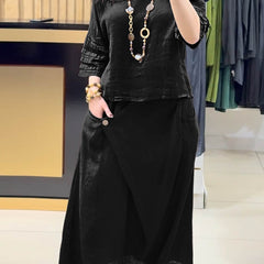 Black two-piece outfit: long-sleeve tunic and gathered midi skirt with pockets