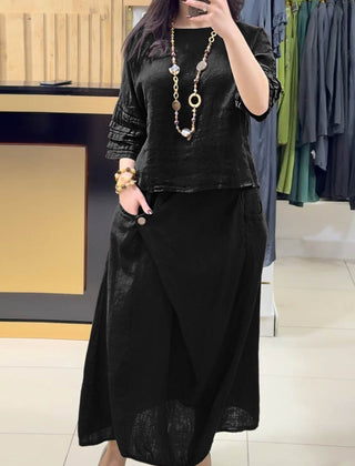Black two-piece outfit: long-sleeve tunic and gathered midi skirt with pockets