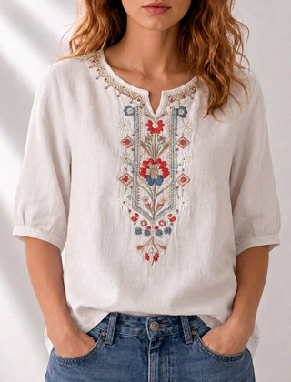 White embroidered floral blouse with puff sleeves and decorative V-neck panel