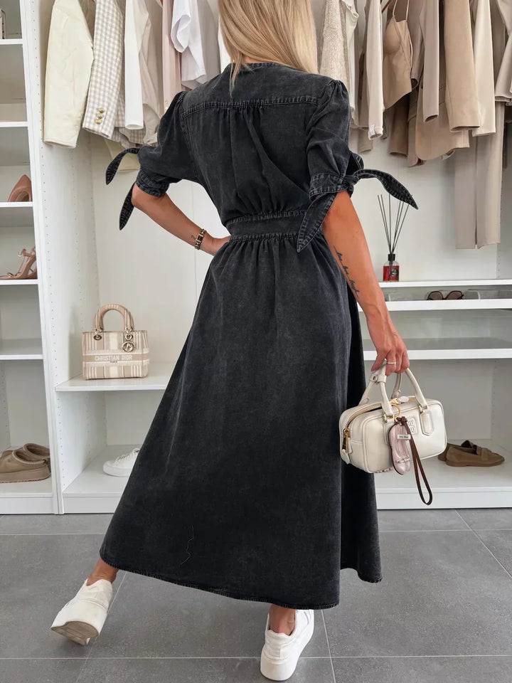 Back view of black denim midi dress with gathered waist and button-front, short sleeves