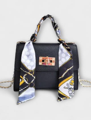 Black handbag with gold clasp, chain strap, and patterned scarf handle