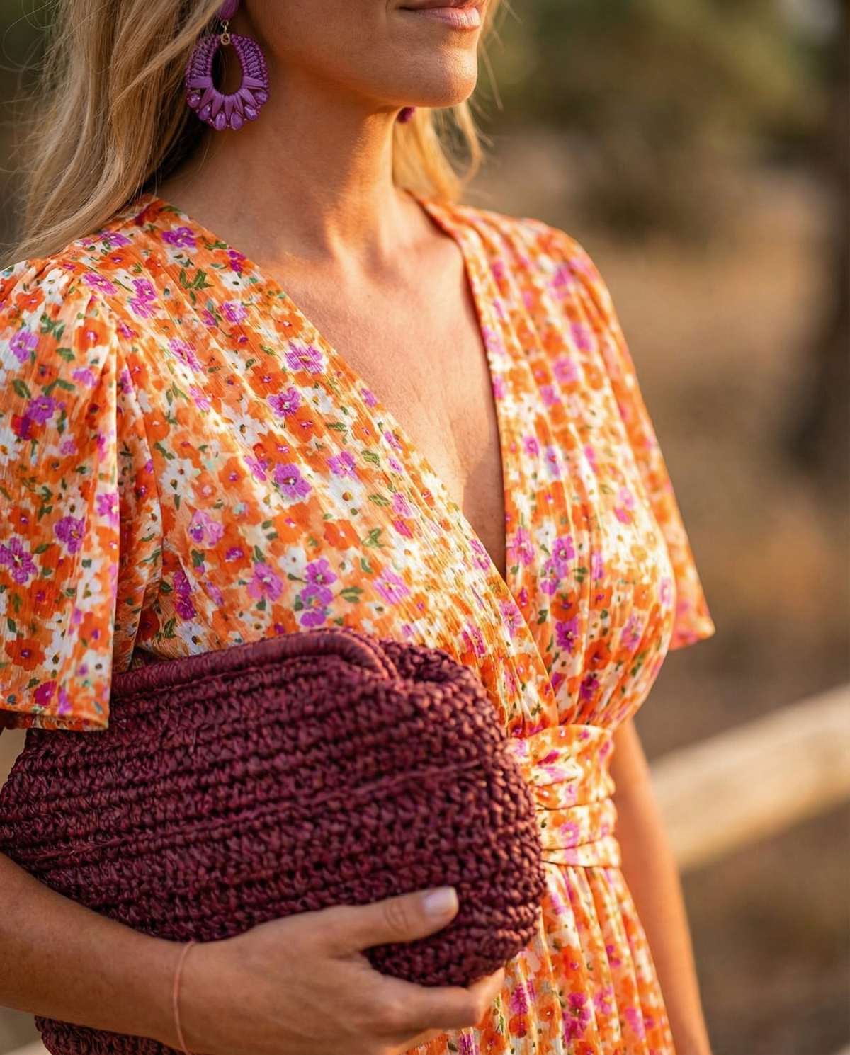 Close-up of orange floral V-neck dress with short puff sleeves and tie waist