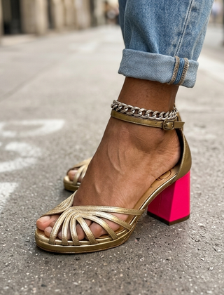 Gold heeled sandals with crisscross straps, chain ankle, and block heel
