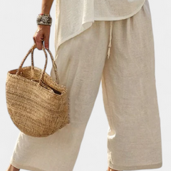 Light cream wide-leg pants with matching raw blouse, loose drape, cropped view
