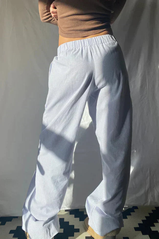 Light blue lounge trousers with elastic waistband and relaxed wide straight legs, cuffed hem
