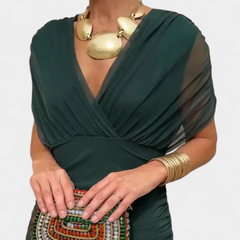 Long dark green draped V-neck dress with sheer sleeve panels and gathered waist