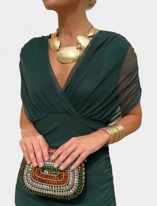 Long dark green draped V-neck dress with sheer sleeve panels and gathered waist