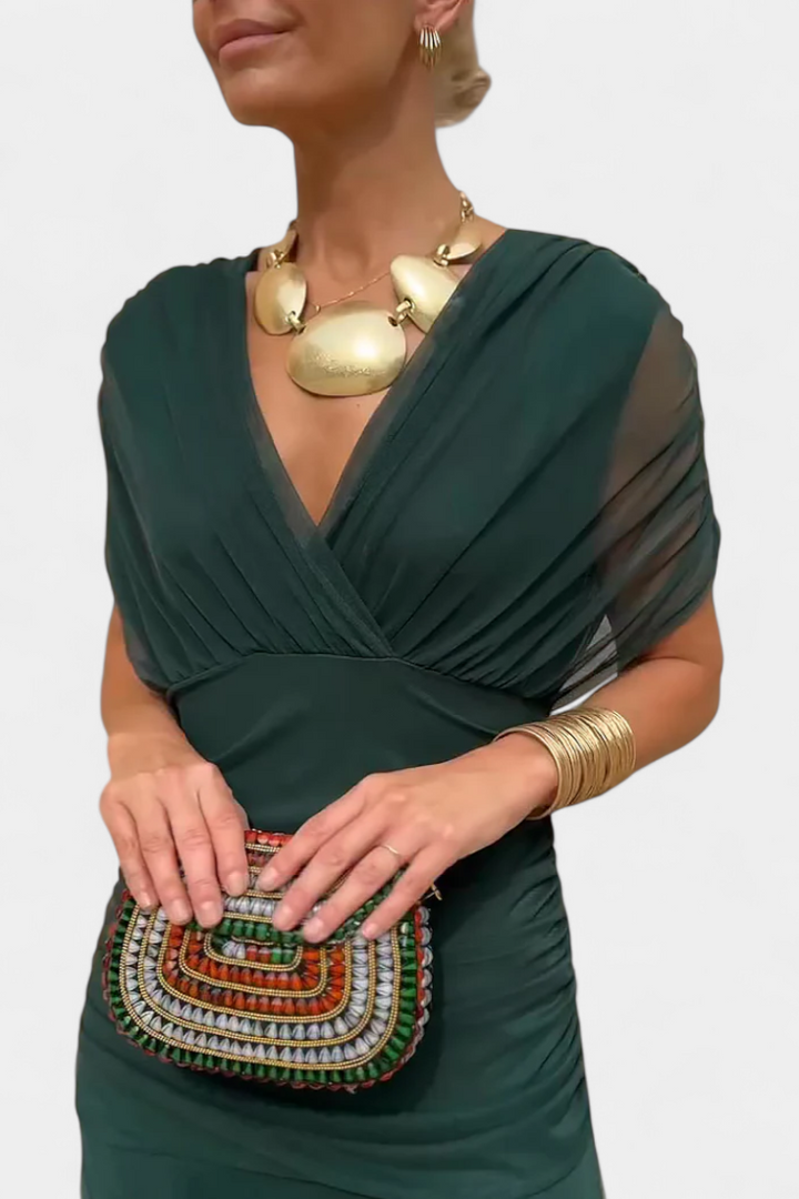 Long dark green draped V-neck dress with sheer sleeve panels and gathered waist
