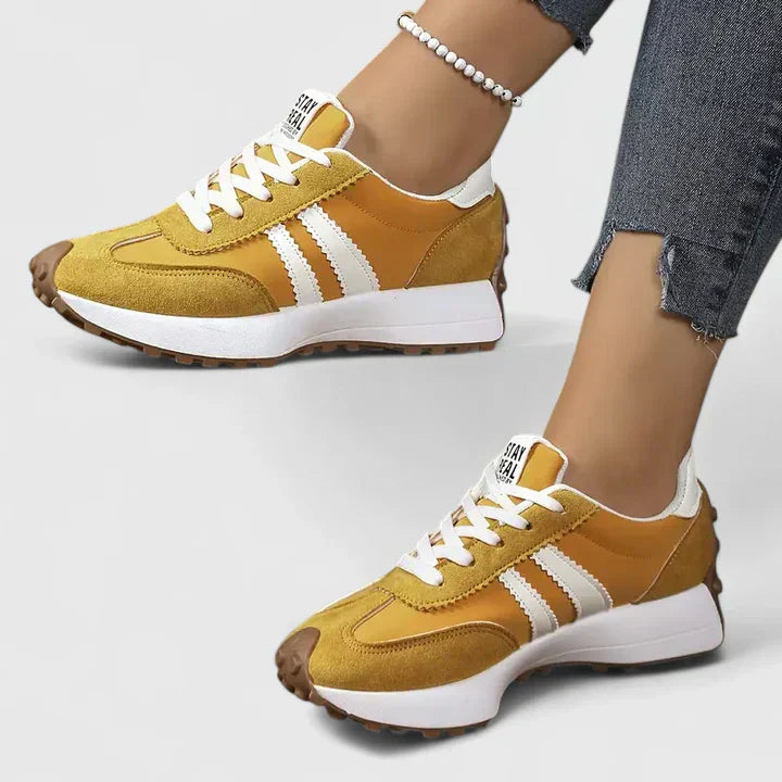 Yellow lace-up orthopedic sneakers with white stripe accents and cushioned sole
