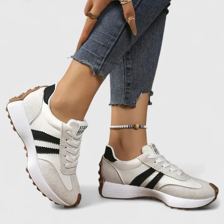 White lace-up orthopedic sneakers with black stripe accents and cushioned sole