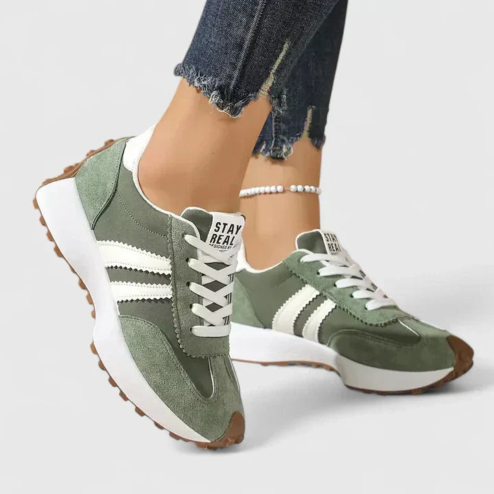 Green lace-up orthopedic sneakers with white stripe accents and cushioned sole