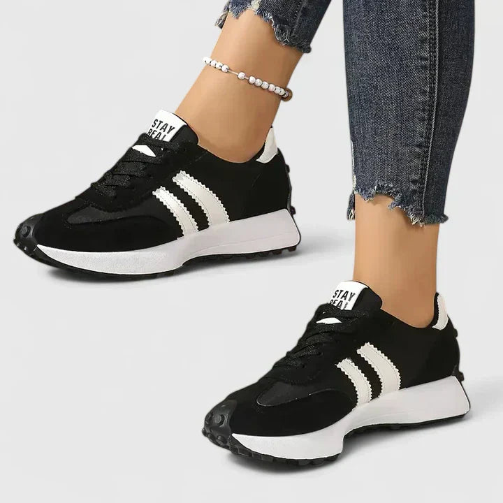 Black lace-up orthopedic sneakers with white stripe accents and cushioned sole