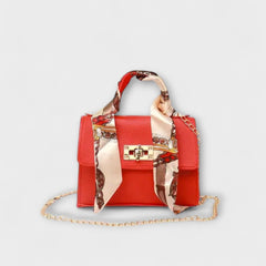 Red handbag with gold clasp, chain strap, and red patterned scarf handle