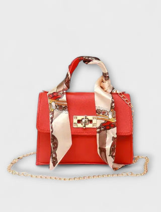 Red handbag with gold clasp, chain strap, and red patterned scarf handle