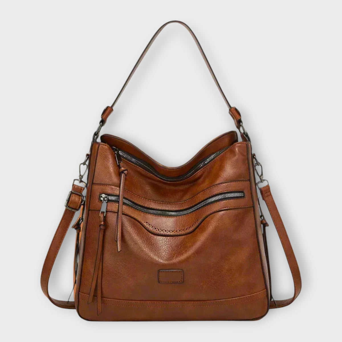 Brown hobo shoulder bag with front zipper pocket and tassel, side strap hardware