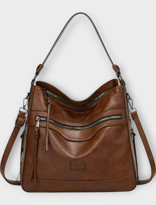Coffee brown shoulder bag with front zip pocket and hanging tassel, adjustable straps