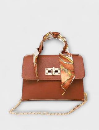 Light brown handbag with gold clasp, chain strap, and patterned scarf handle