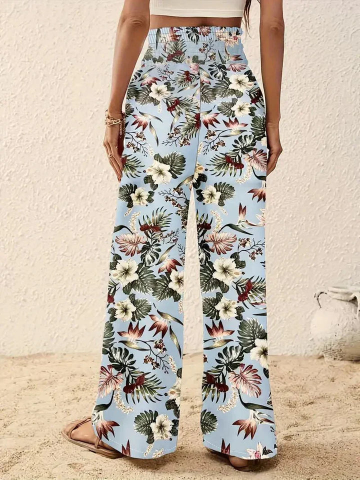 Light blue wide-leg trousers with scattered tropical flowers and foliage print