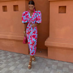 Women’s printed midi dress with puff sleeves and V-neck in pink and blue floral pattern.