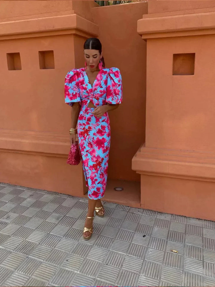 Women’s printed midi dress with puff sleeves and V-neck in pink and blue floral pattern.