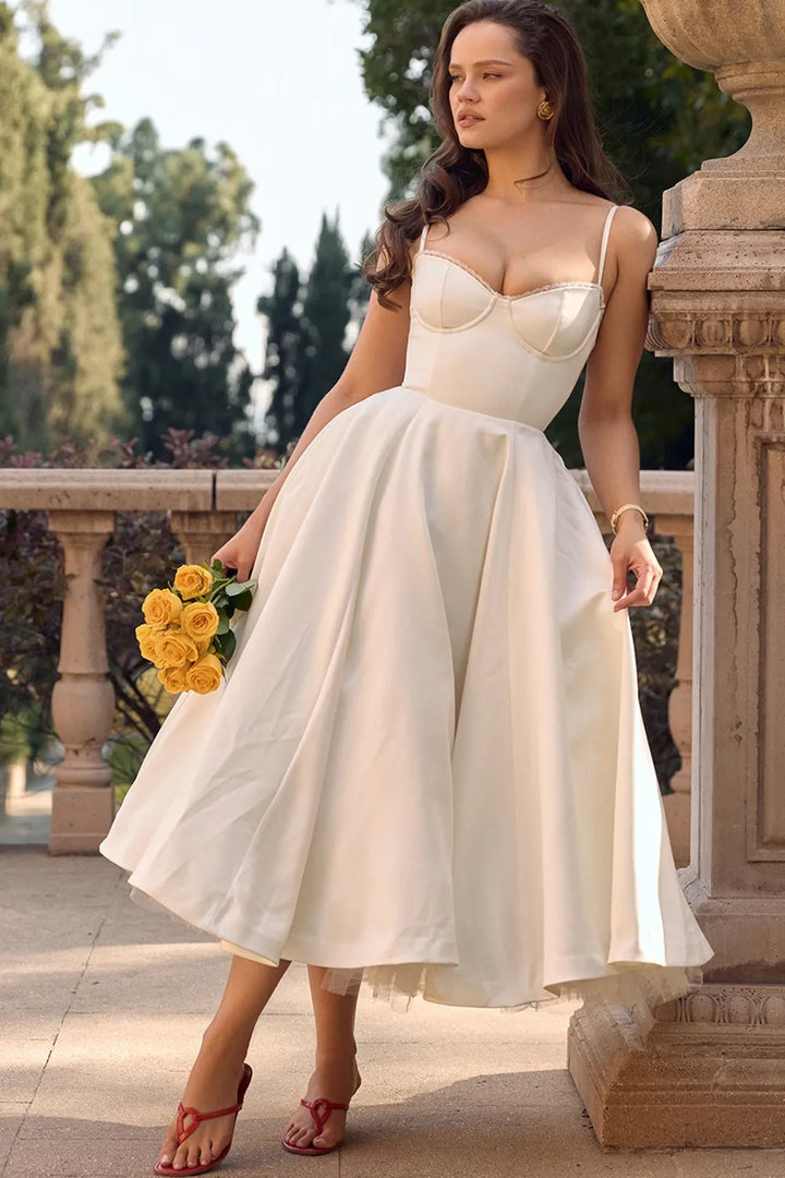Ivory fit-and-flare dress with spaghetti straps, sweetheart bodice, and flared tulle skirt.
