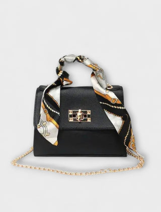 Black handbag with gold clasp, chain strap, and patterned scarf handles