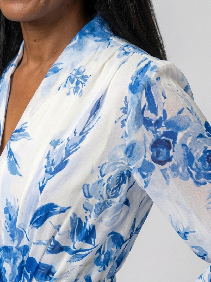 Blue floral long-sleeve wrap dress close-up on shoulder and sleeve; lightweight fabric