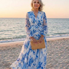 Floral long-sleeve wrap maxi dress in white with blue blooms; tied waist and tiered skirt