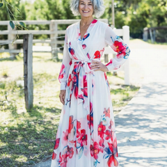 Floral long-sleeve wrap maxi dress in white with red and pink blooms; tied waist