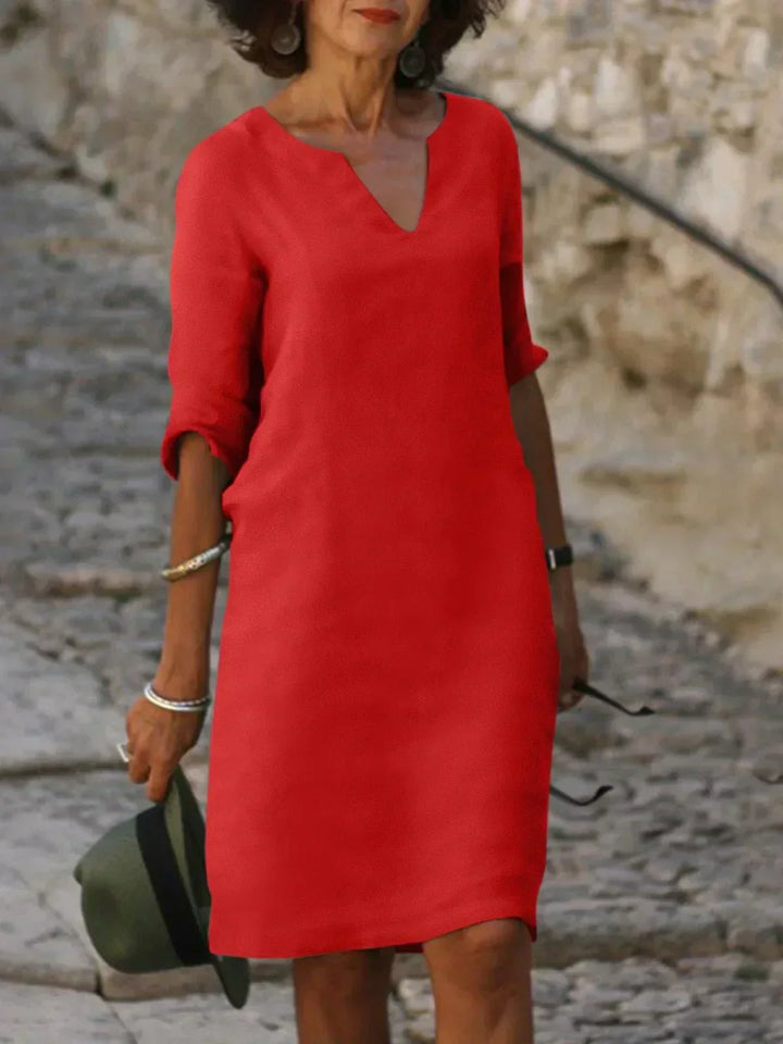 White V-neck dress with elbow-length sleeves and a straight, knee-length fit