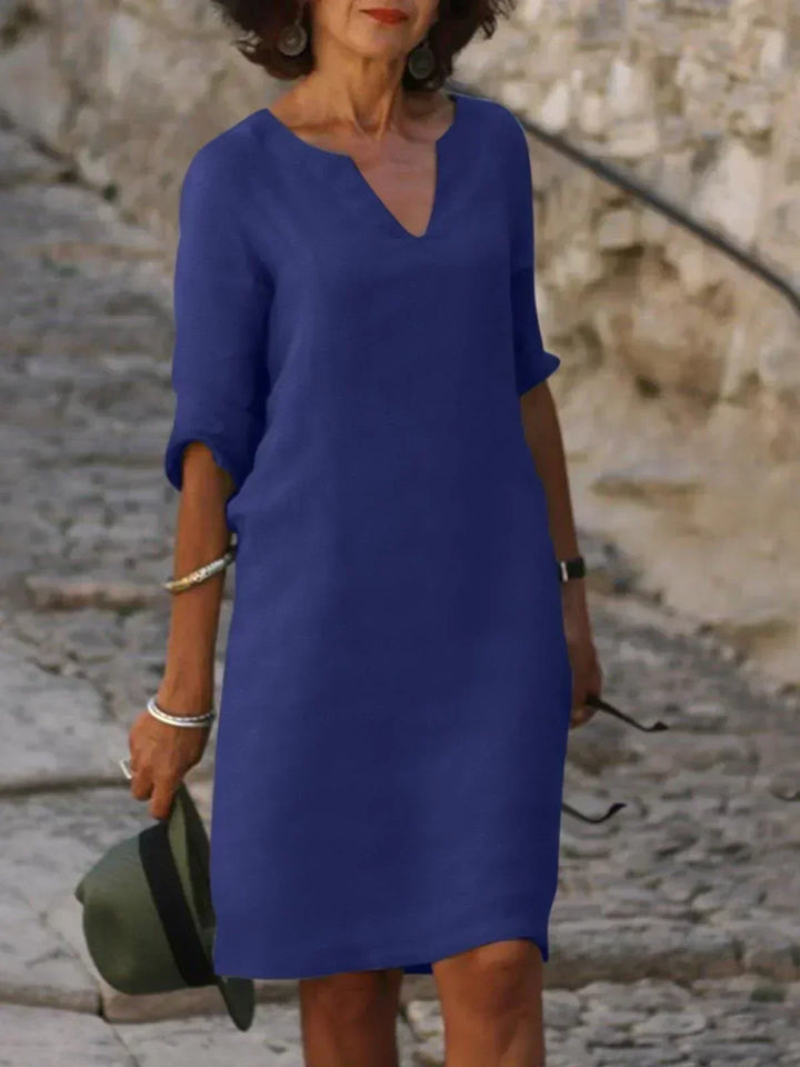 Deep blue V-neck dress with elbow-length sleeves and a straight, knee-length fit