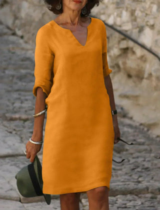 Red V-neck dress with elbow-length sleeves and a straight, knee-length fit