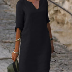 Black V-neck dress with elbow-length sleeves and a straight, knee-length fit