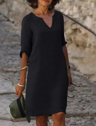 Green V-neck dress with elbow-length sleeves and a straight, knee-length fit