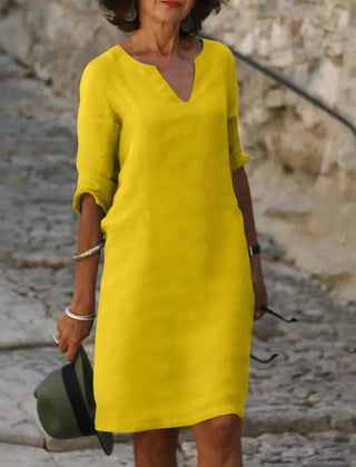 Navy blue V-neck dress with elbow-length sleeves and a straight, knee-length fit