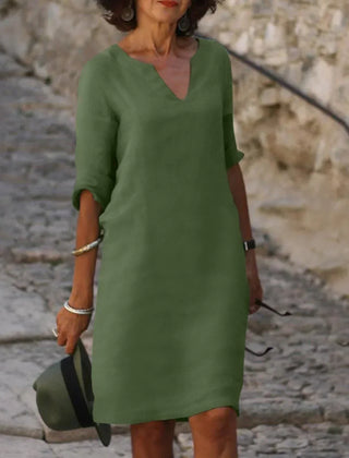 Light green V-neck dress with elbow-length sleeves and a straight, knee-length fit