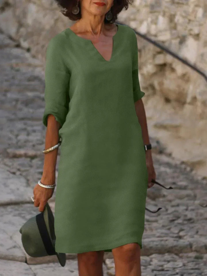 Light green V-neck dress with elbow-length sleeves and a straight, knee-length fit