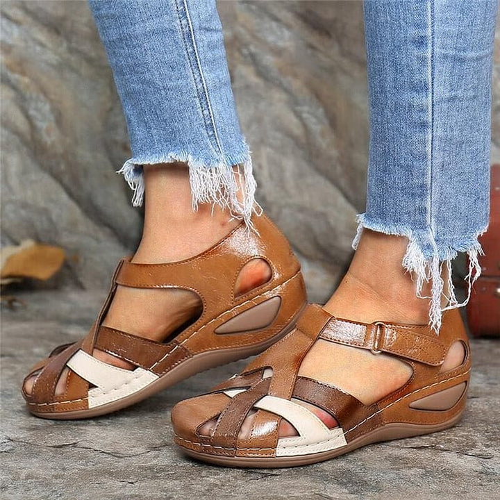 Brown casual sandals with tan straps and cutout design on cushioned sole