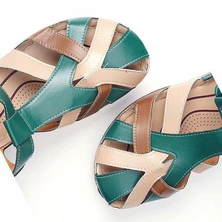 Close-up teal and beige leather sandals with cross straps and cushioned sole
